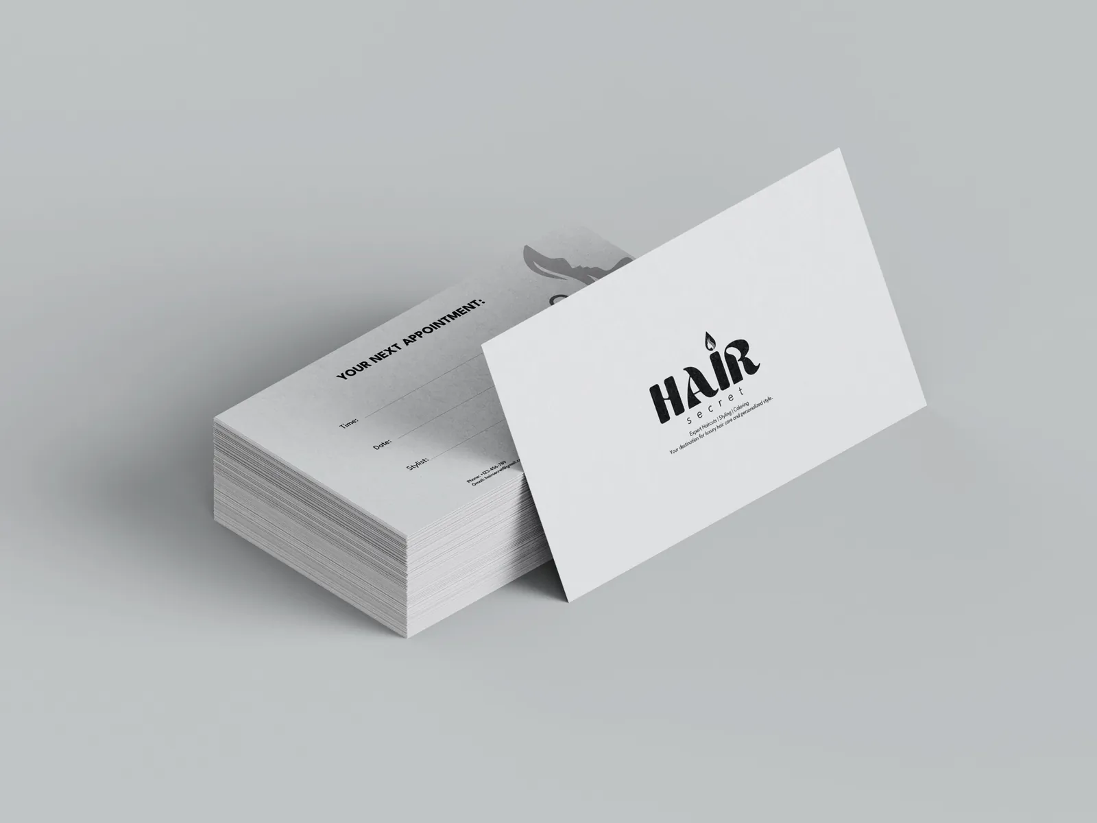 Hair Secret appointment cards in black and white on a pale grey background