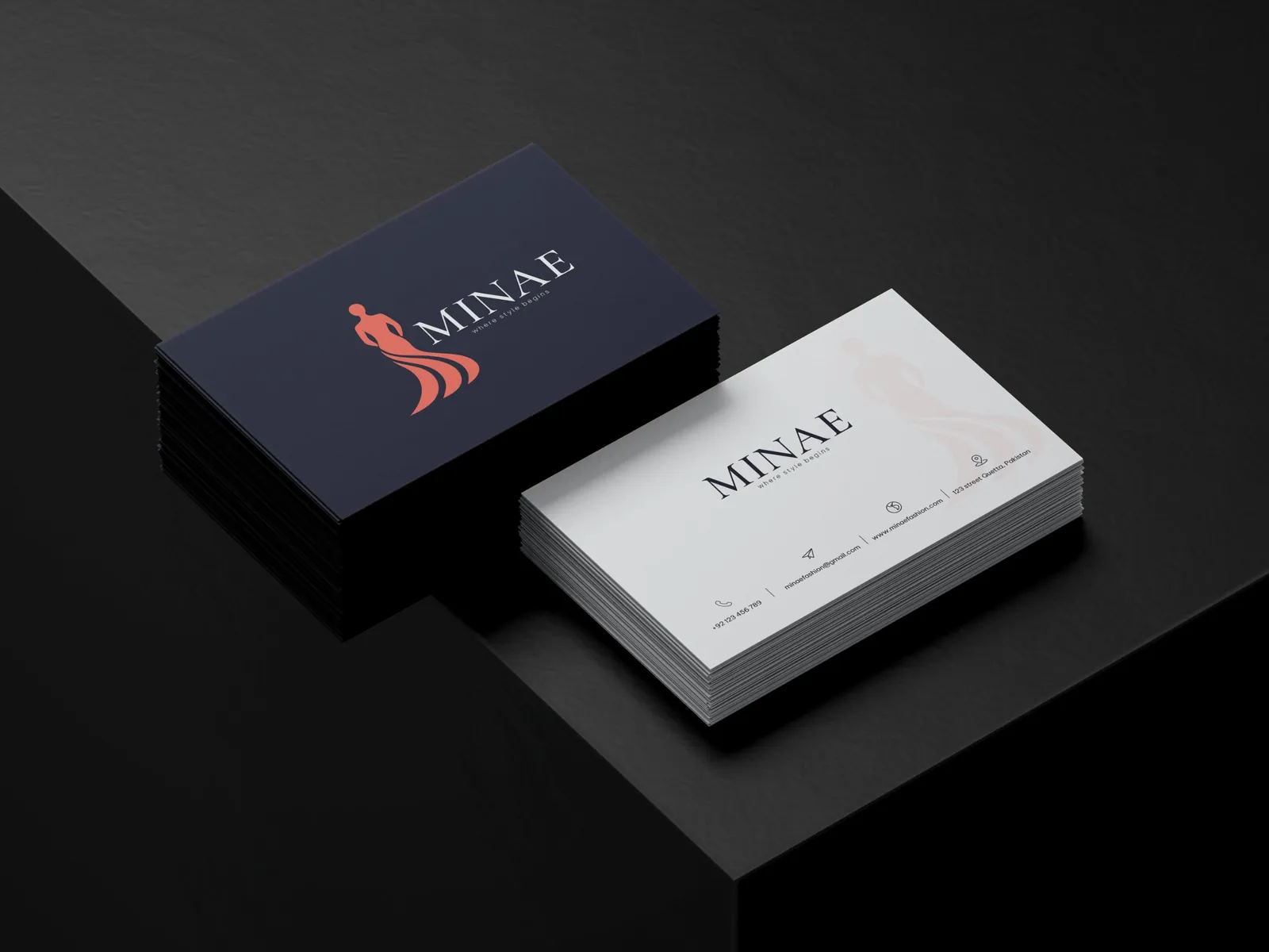 Minae business cards, one navy with a coral figure logo and one white, stacked on a black surface